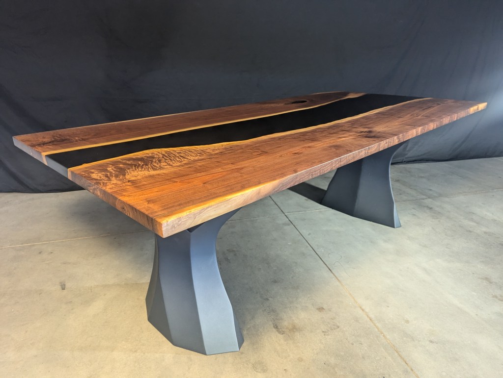A handcrafted black walnut dining table featuring live-edge details and modern polished steel legs. The table is 84 inches long, 40 inches wide, and 29 inches tall, accommodating 6 to 8 guests.