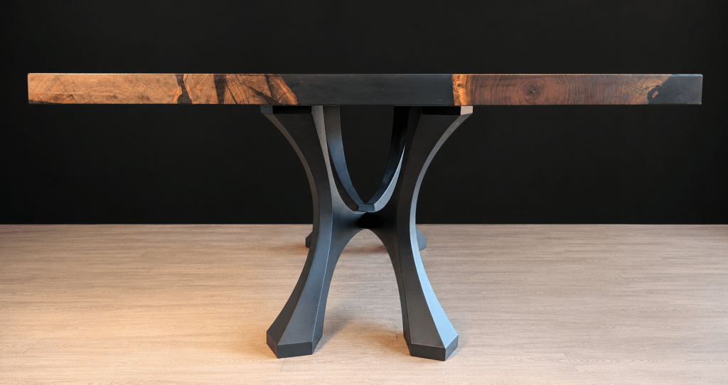 Side profile of an adjacent-slab black walnut dining table showing the slab thickness and pedestal base.