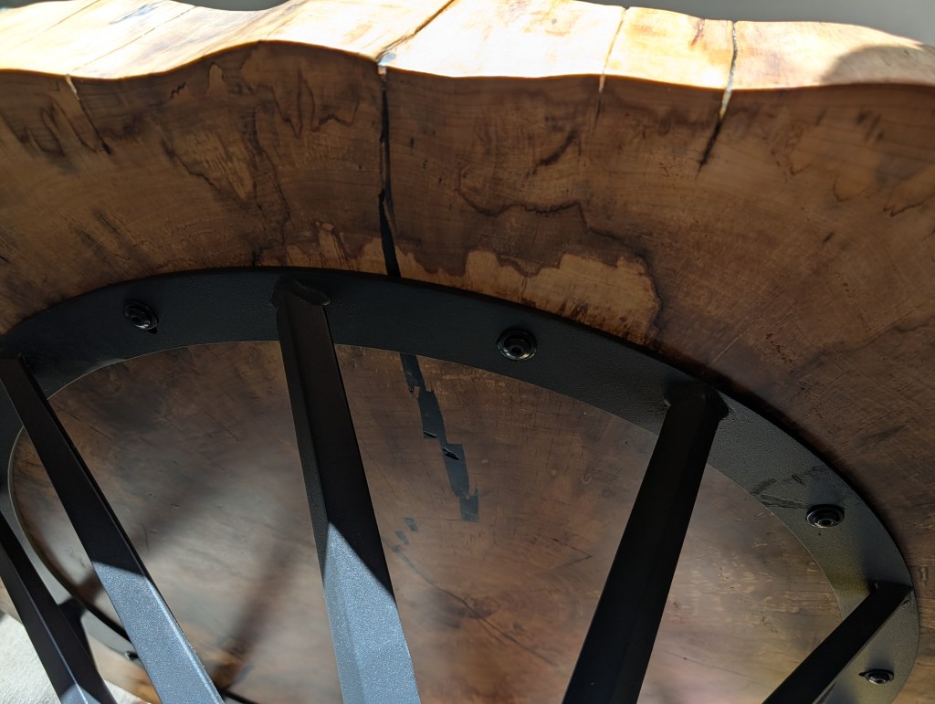 Close-up of underside mounting Close-up of underside mounting plate and steel base attachment on handcrafted cottonwood coffee table.